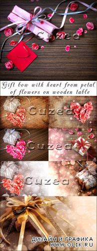 Подарок с сердцем из лепестков роз на деревянном столе
